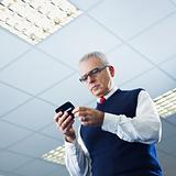 mature businessman reading e-mails on cellphone
