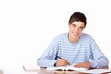Young happy handsome male student sitting on desk learning for e