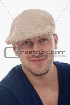 studio portrait of a young handsome man with cap, smiling