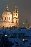 prague - view of snowy rooftops and st. nicolaus church in winter