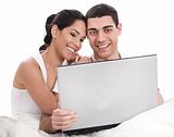 Couple sitting in bed with laptop