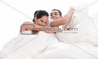 Playful young beautiful couple with pillows 