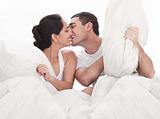 Couple kissing and playing on bed in bedroom, in passion