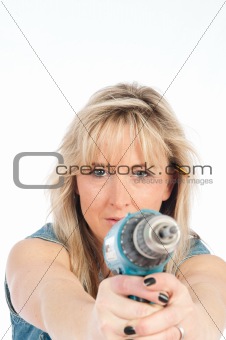 Young blonde woman works with a cordless electric screwdriver
