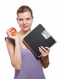 smiling young woman holding a weight scale and red apple