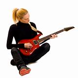 girl playing an electric guitar sitting down