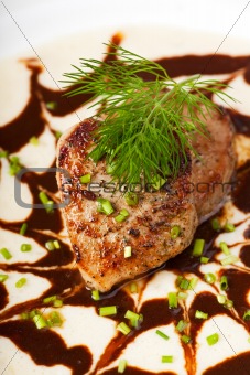 small veal steak on a bed of sauce