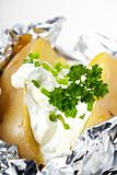 closeup detail of a baked potato with sour cream