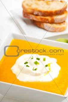 pumpkin soup and baguette isolated on white
