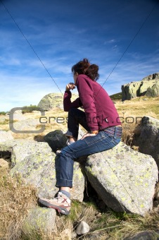 jeans woman sitting on rock