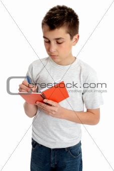 School boy writing in book