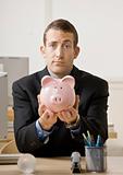 Young Businessman Holding Piggy Bank