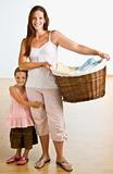 Mother holding laundry basket with daughter near