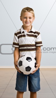 Young boy holding soccer ball