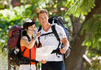 Couple with backpacks looking at map