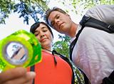 Couple with backpacks looking at compass