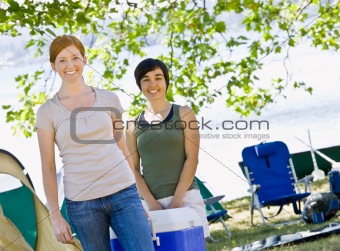 Women carrying cooler at campsite