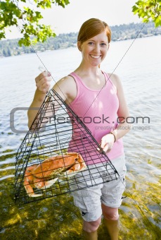 Woman holding crab in trap