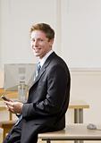 Businessman text messaging on cell phone