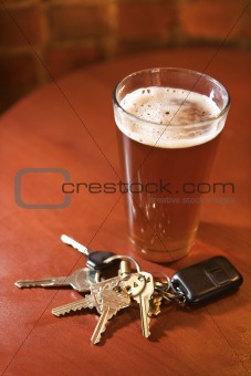 Glass of Beer and Keys on Bar Table