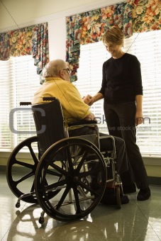 Elderly Man in Wheelchair and Young Woman