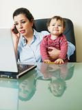 businesswoman on the phone, holding daughter