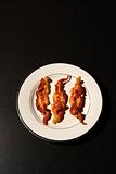 Three Strips of Cooked Bacon on White Plate