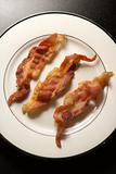 Three Strips of Cooked Bacon on White Plate