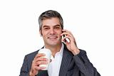 Smiling Businessman on phone while drinking a coffee