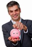 Businessman saving money in a piggybank 