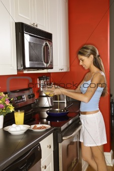 Attractive Young Woman in Kitchen Cooking Breakfast