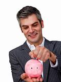 Assertive Businessman saving money in a piggybank 