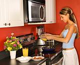Attractive Young Woman in Kitchen Cooking Breakfast