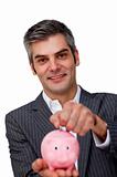 Self-assured Businessman saving money in a piggybank