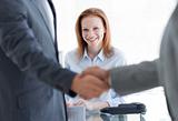 Businesswoman smiling with businessmen greeting each other in th