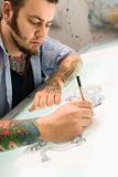 Man drawing tattoo.