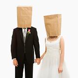 Wedding couple with bags over heads.