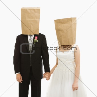 Wedding couple with bags over heads.