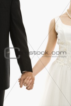 Wedding couple holding hands.