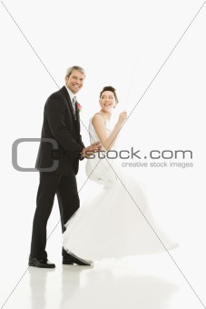 Groom pushing bride in swing.