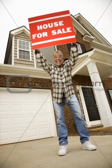 Middle-aged man holding a for sale sign.