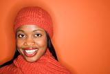African-American woman wearing orange scarf and hat.