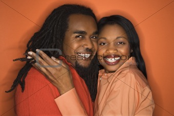 African-American couple wearing orange clothing on orange backgr