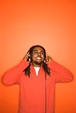 African-American man listening to headphones.
