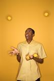 African-American man juggling lemons.