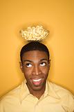 African-American man balancing bowl of popcorn on head.