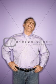 Laughing Caucasian man wearing purple clothing.