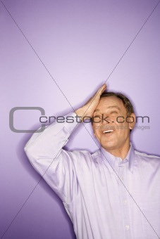 Caucasian man with his hand on forehead.