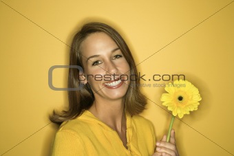Young Caucasian woman holding flower.