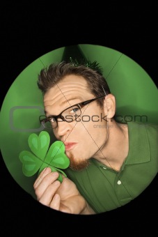 Caucasian man kissing shamrock.